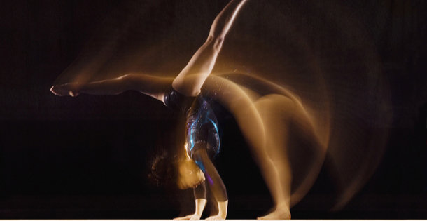 Gymnast in mid-motion on a balance beam