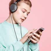 Woman with headphones listening to music on her phone.