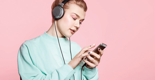 Woman with headphones listening to music on her phone.