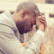 Depressed man with his head in his hands.