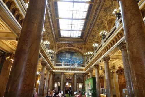 The lobby of a casino, with columns, a skylight, and gold panels