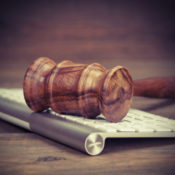 A gavel rests on an Apple keyboard.