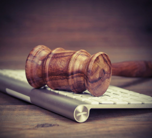 A gavel rests on an Apple keyboard.