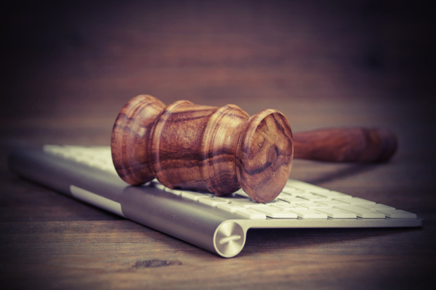 A gavel rests on an Apple keyboard.