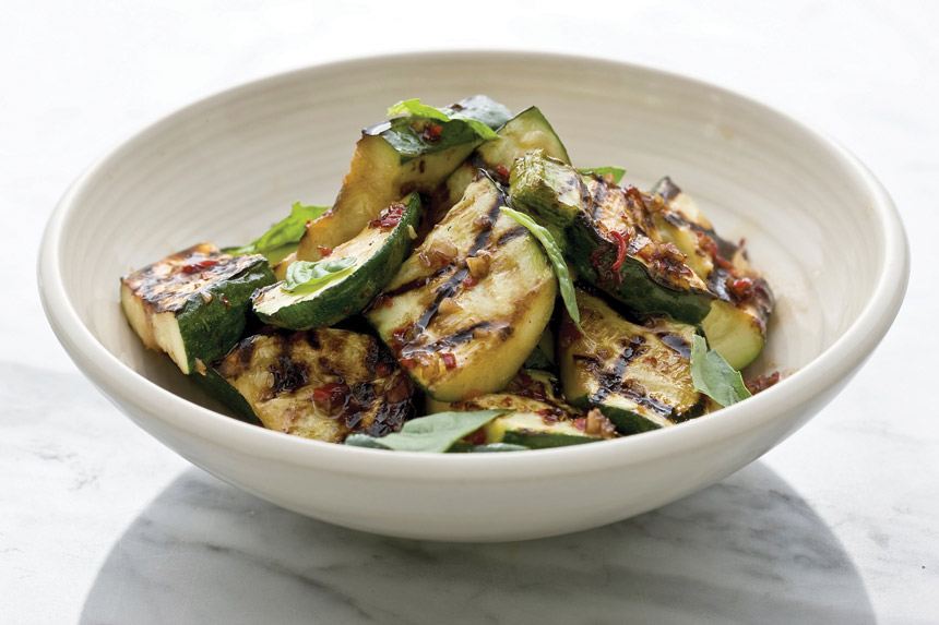 Grilled slices of zucchini in a bowl.