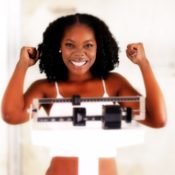 Young woman smiling on a weight scale.