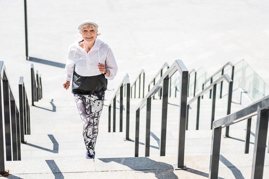 Elderly woman running up a set of stairs during a jog