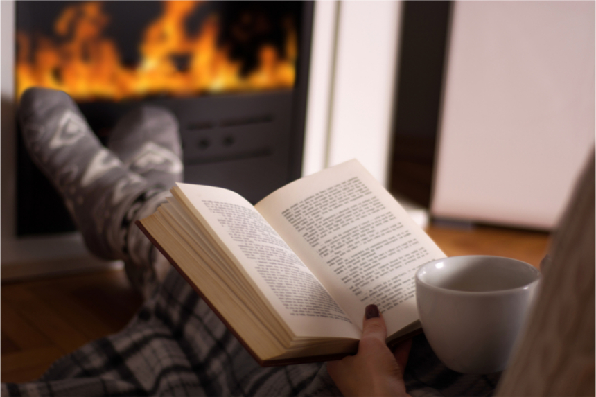 Reading a book in front of a fireplace