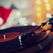 A Christmas music record plays on a turntable, and a Santa's hat can be seen in the background.