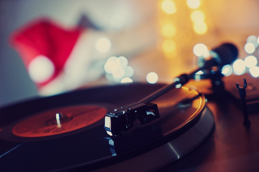 A Christmas music record plays on a turntable, and a Santa's hat can be seen in the background.
