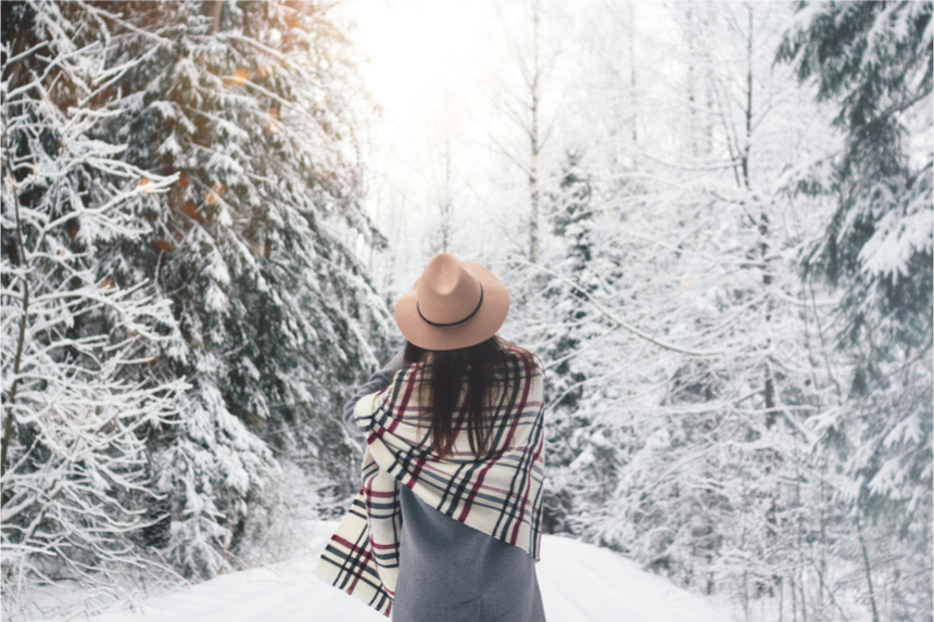 Woman enjoying a walk in a snowy wood