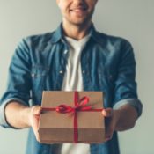 Man handing over a wrapped holiday gift