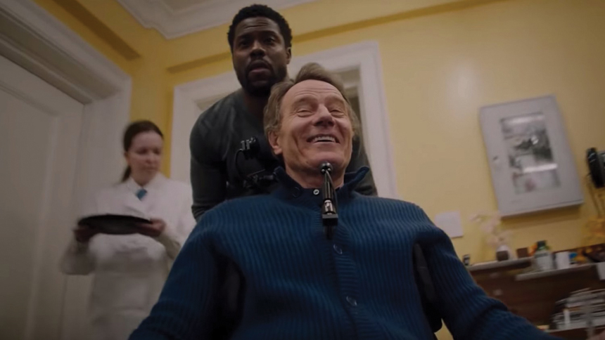 Bryan Cranston being pushed in a wheelchair by Kevin Hart in the film, The Upside