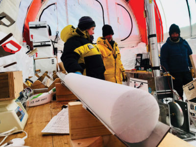 Glaciologists prepare an glacier's ice core for preservation