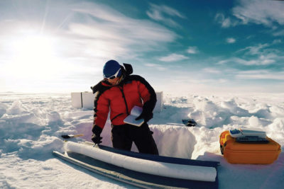 A glaciologist taking a sample from a glacier's ice core.