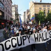 Protesters march in lower Manhattan during an Occupy Wall Street protest, with placards reading "No to Wall Street's dictatorship"