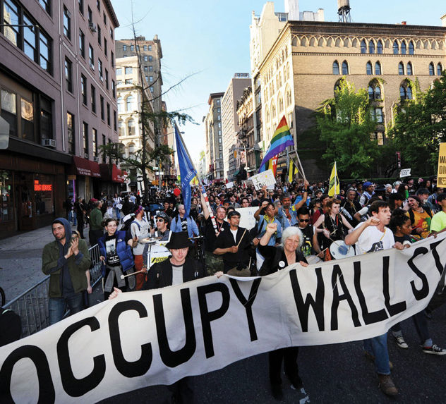 Protesters march in lower Manhattan during an Occupy Wall Street protest, with placards reading "No to Wall Street's dictatorship"