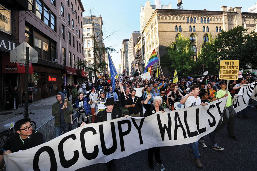 Protesters march in lower Manhattan during an Occupy Wall Street protest, with placards reading "No to Wall Street's dictatorship"