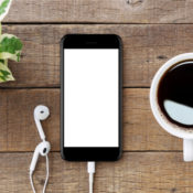 An iPhone and a cup of coffee on a wooden table