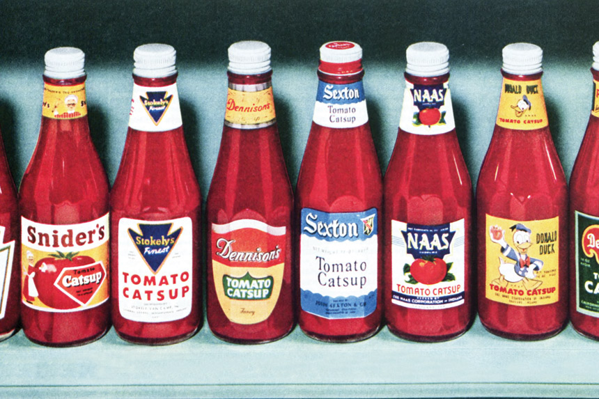Ketchup bottles neatly aligned in a row on a shelf.
