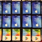 A collection of Apple and Google gift cards hanging on a store's rack.