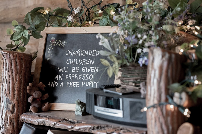 Small chalkboard sign on a counter that reads "Unattended children will be given espresso and a free puppy"