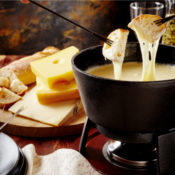 Bread being dipped into a hot, cheesy pot of fondue