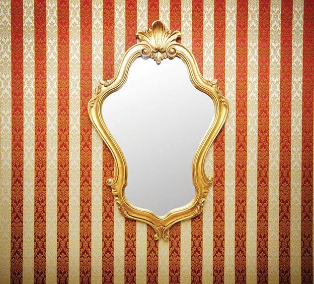 An elegant, gold-trimmed mirror on a wall.