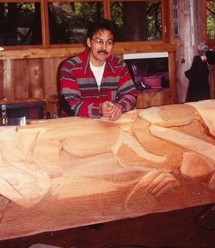 Carver Lee Wallace at work with a giant totem pole.