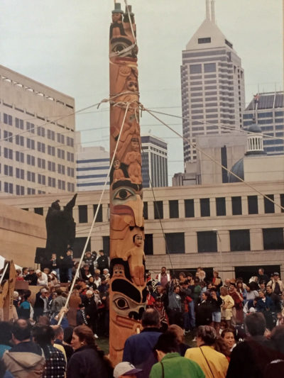 Raising a totem pole in front of a crowd in Indianapolis