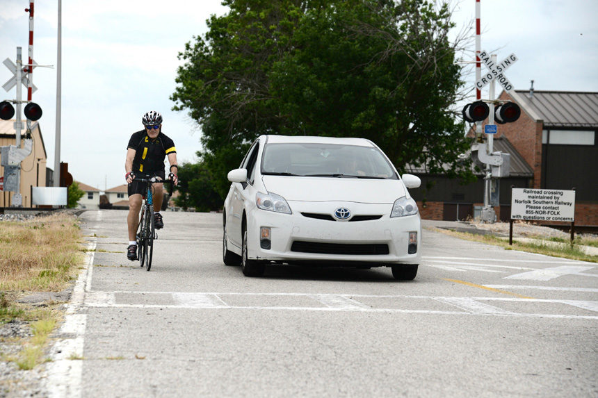 Motorist keeping their car about 3 feet away from a cyclist as he passes by their passenger side.