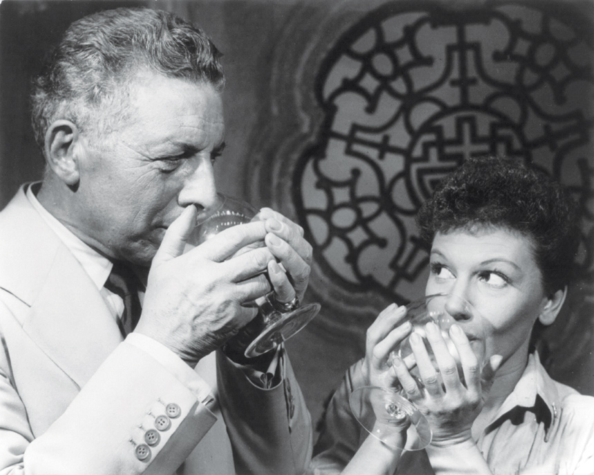Actors Ezio Pinza and Mary Martin drink out of glasses