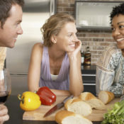 Friends eating lunch and drinking wine at a dinner table.