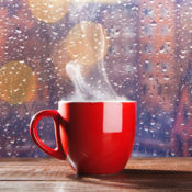 Hot tea in front of a wet window.
