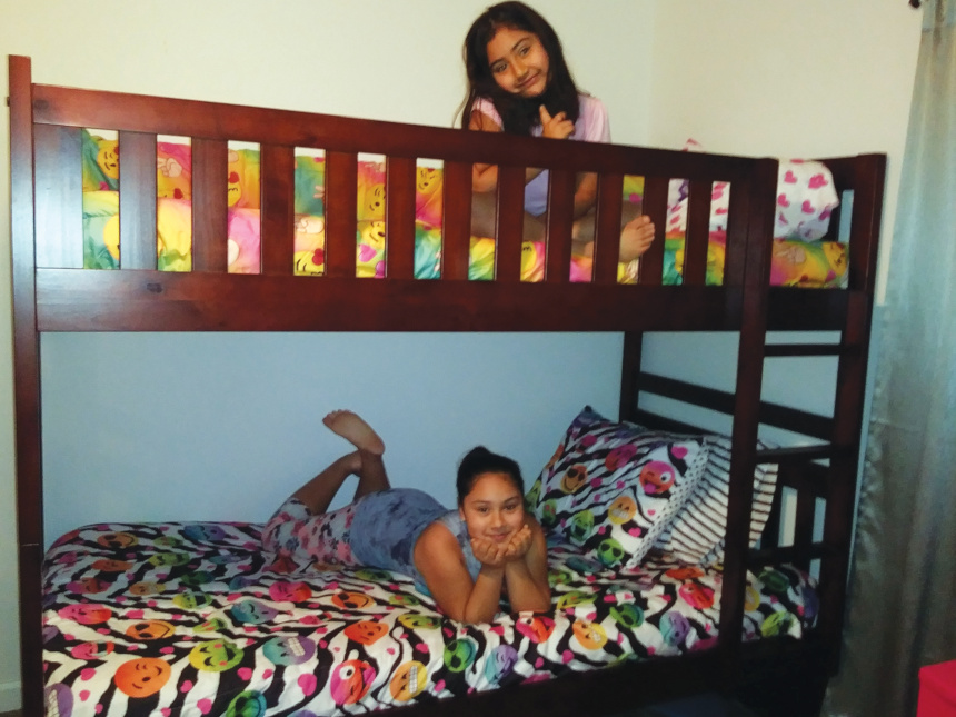A pair of sister who were experiencing homelessness in a bunk bed provided by the group Sweet Dream Makers