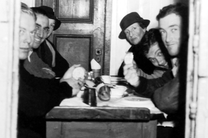 American explorer Louise Arner Boyd and the crew of the SS Veslekar, sitting at a dinner table.