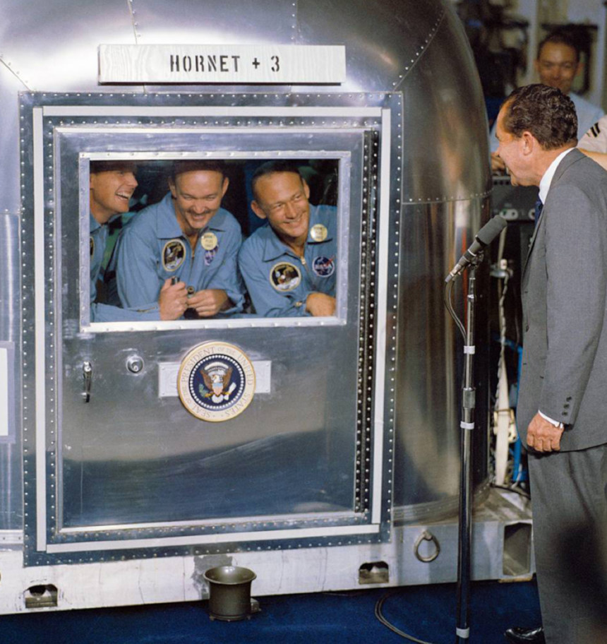 U.S. President Richard Nixon meets with the crew of Apollo 11 as they sit in their recovery chamber.