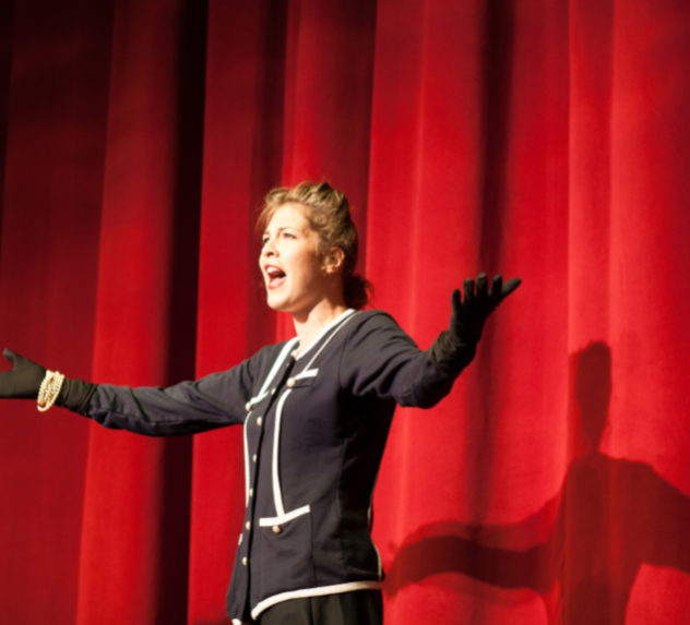 Woman on stage acting.