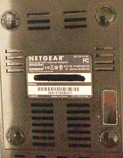 The serial number, MAC address, and the model number of a Netgear WiFi internet adaptor