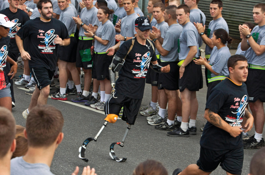 U.S. Army veteran Brendan Marrocco runs during a event in New York city while West Point cadets cheer on.