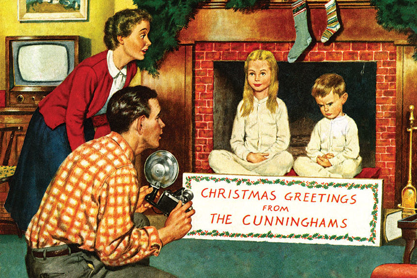 A father and mother takes a Christmas photograph of their children. Their son shows his displeasure as sits next to his patient sister.