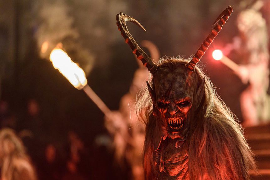 Person dressed up as a devil during a festival.