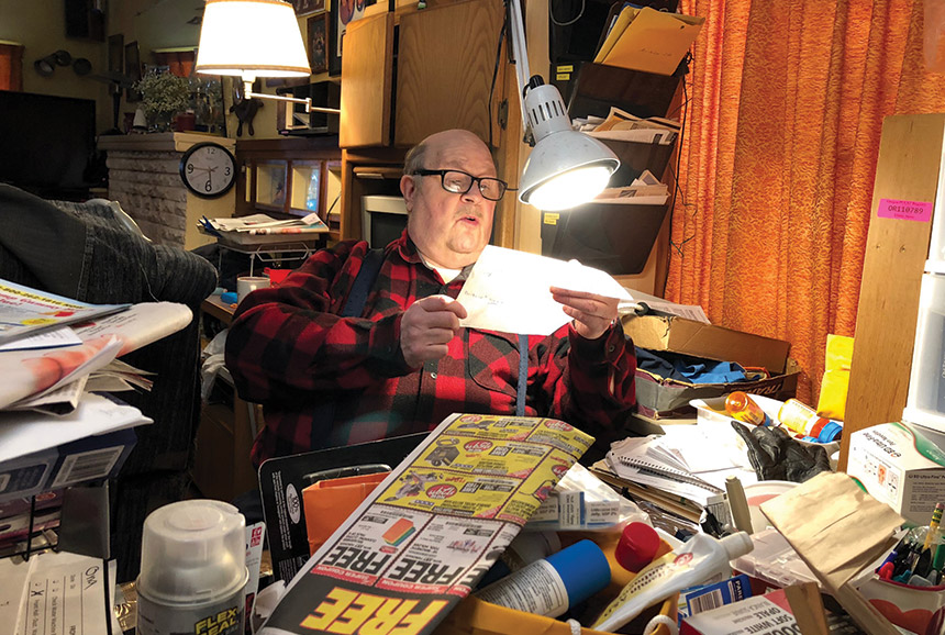 Terry Stone in his home office, perusing through letters.