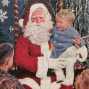 Santa Claus sitting with a small child in his lap.