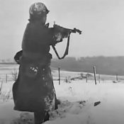 A soldier readers his rifle as he stands in deep snow during The Battle of the Bulge, in World War II.