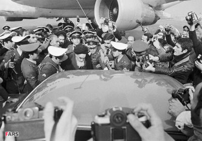 Ayatollah Khomeini climbing into a car after landing at an Iranian airport