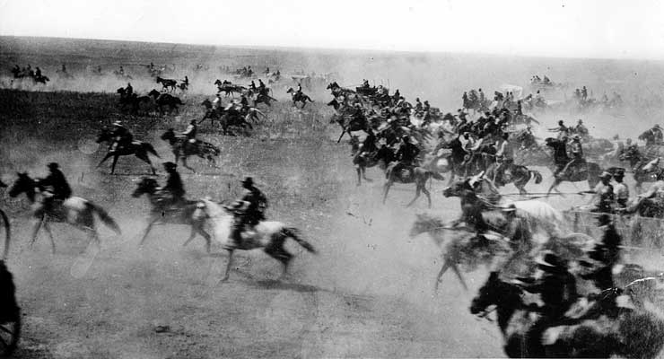 Men on horses rushing to find land during the Oklahoma land rush