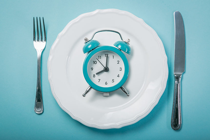 A dinner plate with an alarm clock on it.