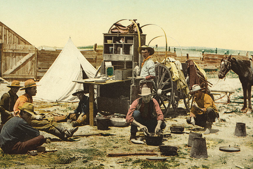 Cowboys having a meal at a campsite.