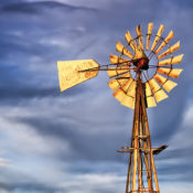 A windmill on a firm in the American midwest.